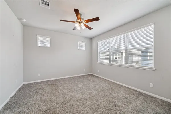 a view of an empty room with a ceiling fan and a window