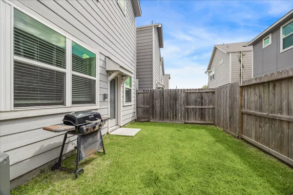 a view of a backyard with sitting area and wooden fence