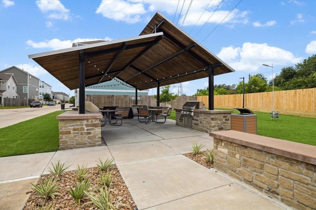 5502 Cuerta Street Houston, TX 77023 - Photo 24 of 25 a view of a patio with table and chairs under an umbrella with a barbeque grill and plants