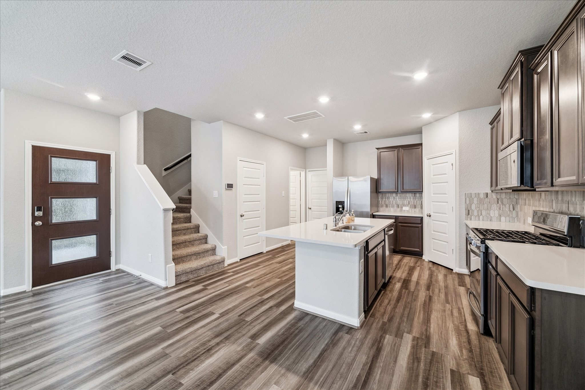 5502 Cuerta Street Houston, TX 77023 - Photo 6 of 25 a kitchen with a sink stainless steel appliances counter space and wooden floor