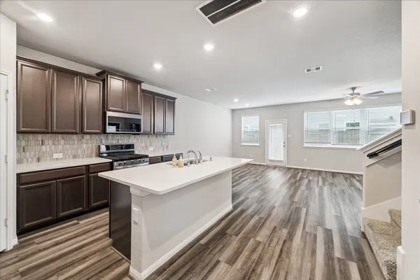 a kitchen with kitchen island sink stove and refrigerator