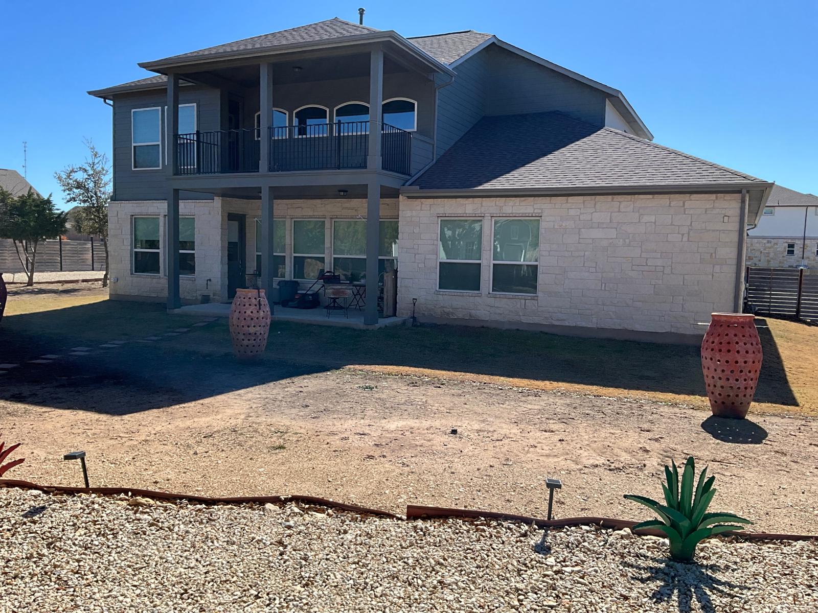 1837 Halflinger Lane Leander, TX 78641 - Photo 28 of 39 Back of property with a patio area, roof with shingles, stone siding, and a balcony