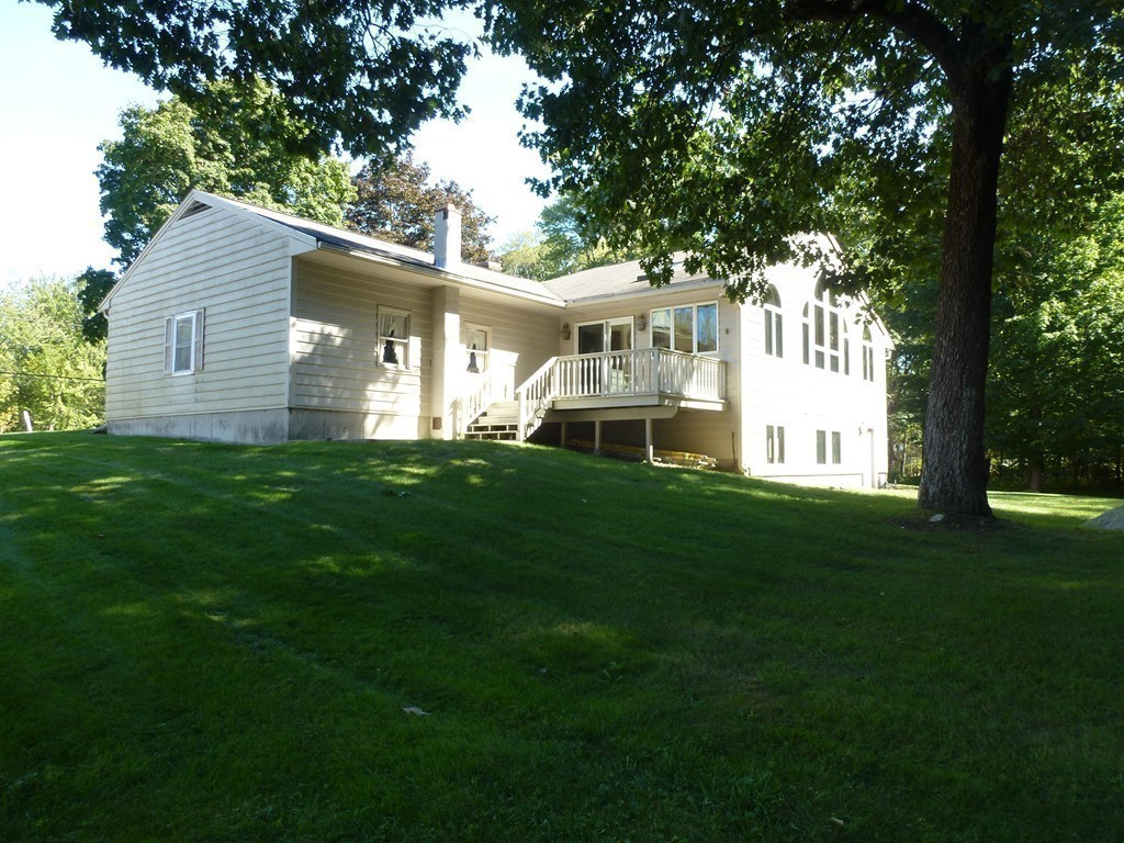 134 Dunstable Road North Chelmsford, MA 01863 - Photo 18 of 26 a view of a house with a big yard potted plants and large tree