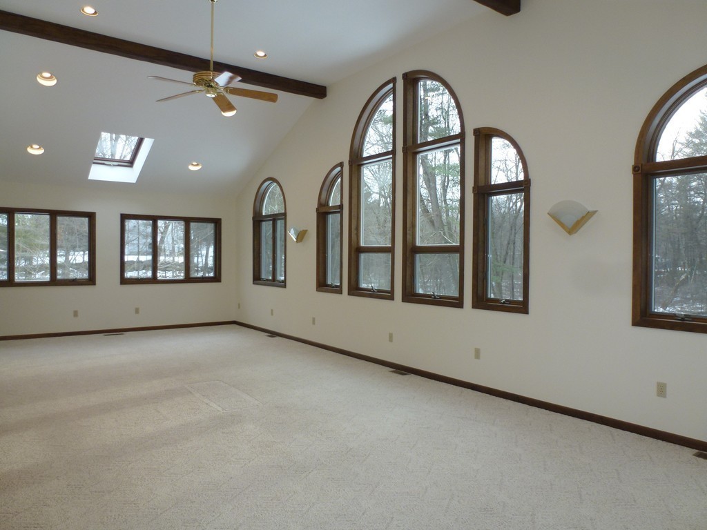 134 Dunstable Road North Chelmsford, MA 01863 - Photo 7 of 26 an empty room with chandelier fan and windows