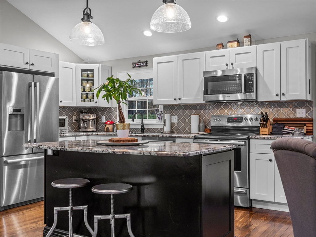 237 York Street Canton, MA 02021 - Photo 8 of 42 a kitchen with stainless steel appliances granite countertop a stove top oven a refrigerator a sink and dishwasher with wooden floor