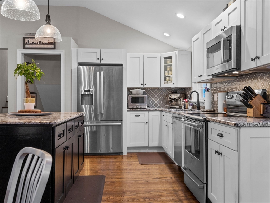 237 York Street Canton, MA 02021 - Photo 9 of 42 a kitchen with stainless steel appliances granite countertop a refrigerator a stove a sink dishwasher and white cabinets with wooden floor