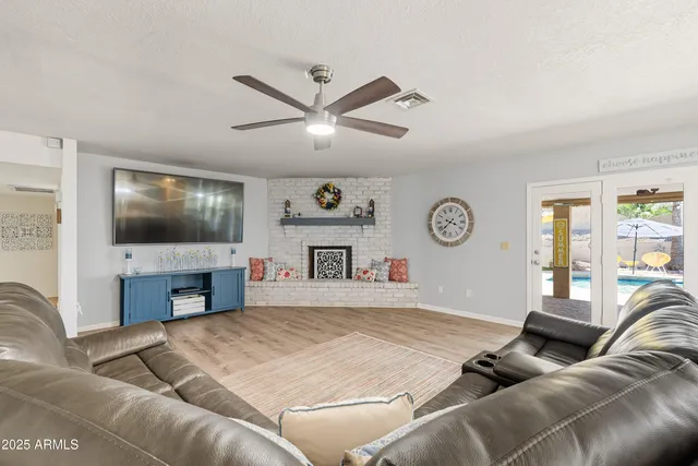 a dining room with furniture a chandelier and wooden floor