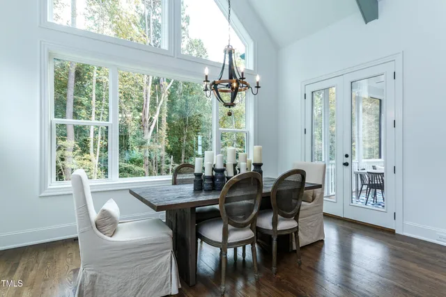 a kitchen with stainless steel appliances kitchen island granite countertop a table chairs sink and cabinets