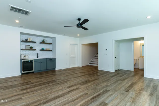 an empty room with windows and fan