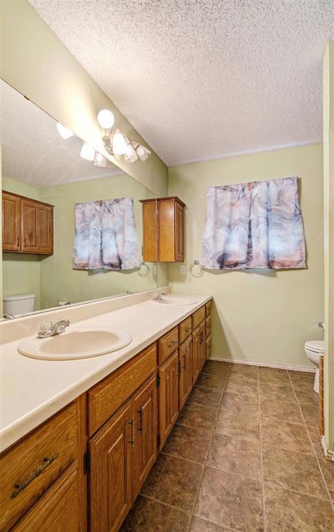 4315 Lakeshore Drive Reno, TX 75462 - Photo 14 of 20 a spacious bathroom with a sink a large mirror and a toilet