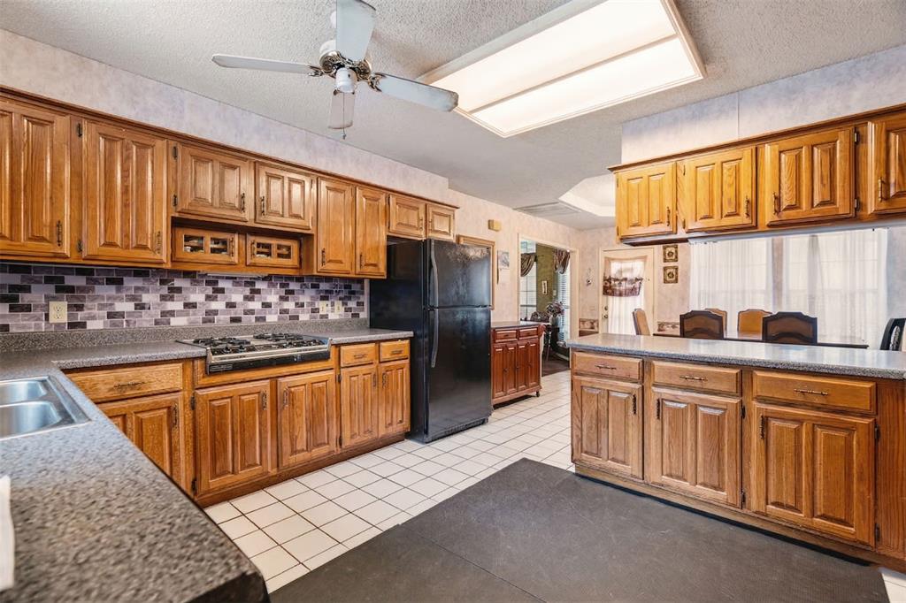 4315 Lakeshore Drive Reno, TX 75462 - Photo 7 of 20 a kitchen with stainless steel appliances granite countertop a sink dishwasher stove and refrigerator with wooden cabinets