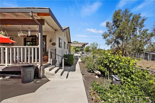 a view of two chairs and table in the patio