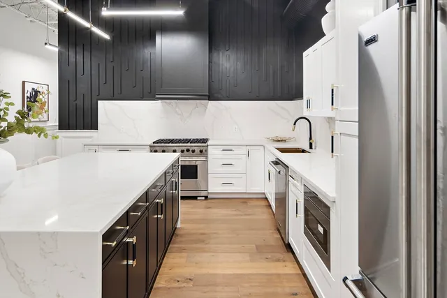 a kitchen with stainless steel appliances a sink dishwasher stove top oven and refrigerator