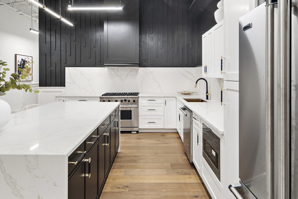 147 Sherman Street, Unit 201 Cambridge, MA 02140 - Photo 12 of 33 a kitchen with stainless steel appliances a sink dishwasher stove top oven and refrigerator