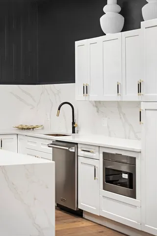 a kitchen with cabinets appliances and a wooden floor