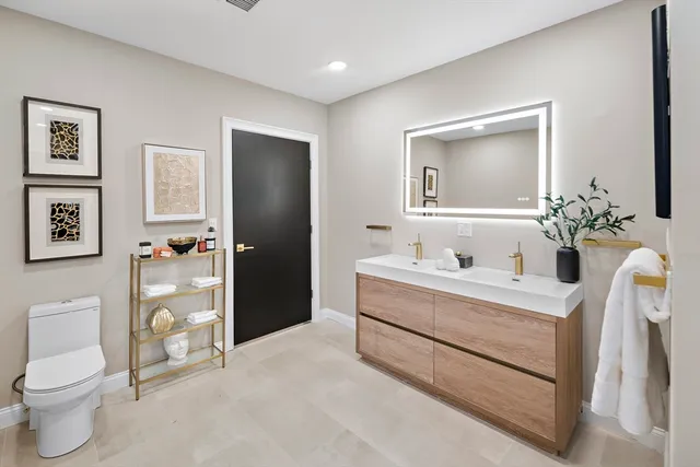 a bathroom with a sink a toilet and a mirror