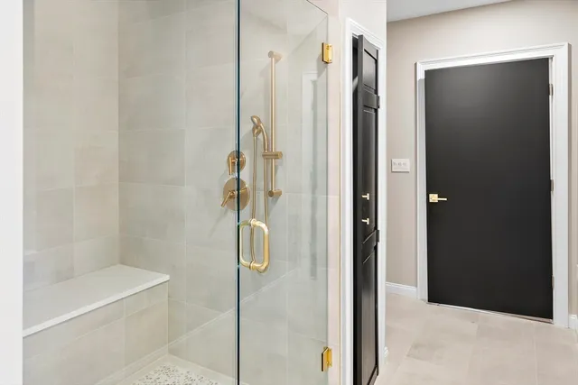 a bathroom with a shower and a glass door