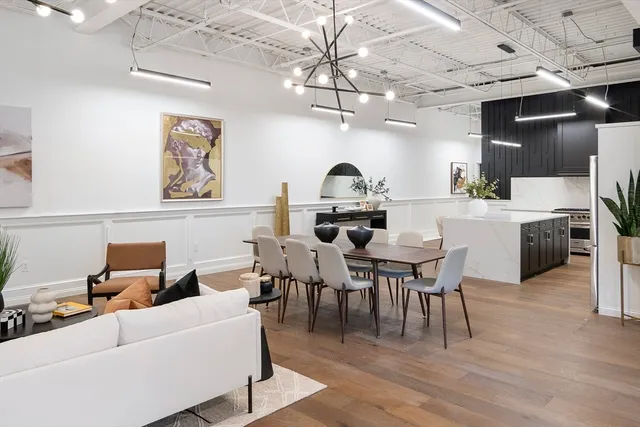 a living room with furniture a chandelier and kitchen view