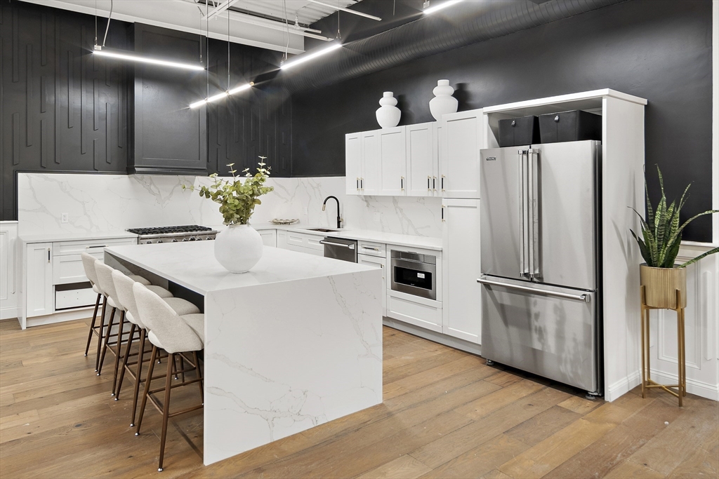 147 Sherman Street, Unit 201 Cambridge, MA 02140 - Photo 3 of 33 a kitchen with kitchen island a white counter top space cabinets and stainless steel appliances