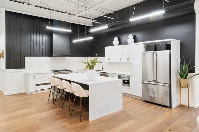 a kitchen with refrigerator and chairs