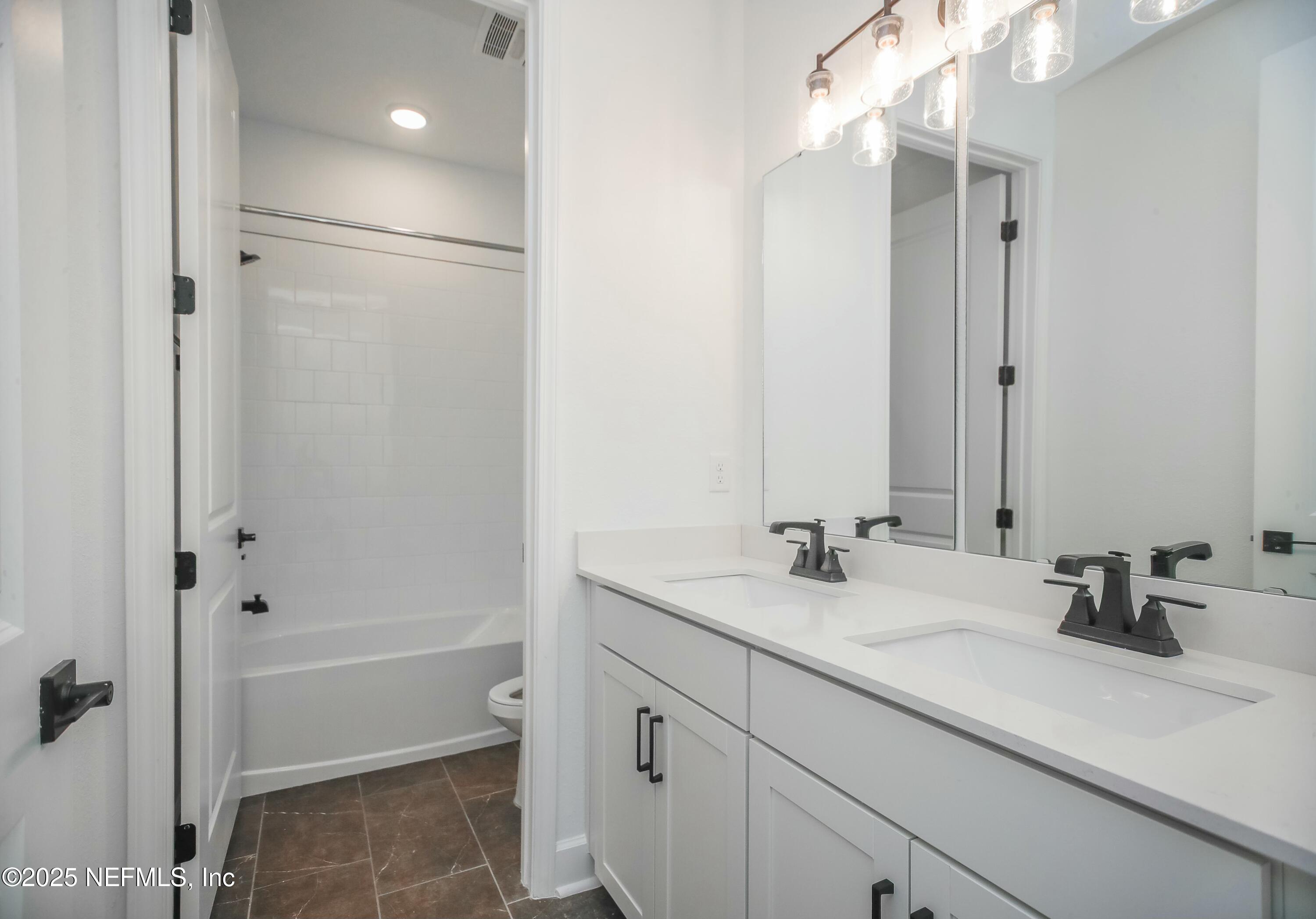 2526 Trailmark Drive St. Augustine, FL 32092 - Photo 18 of 46 a bathroom with a double vanity sink mirror double and shower