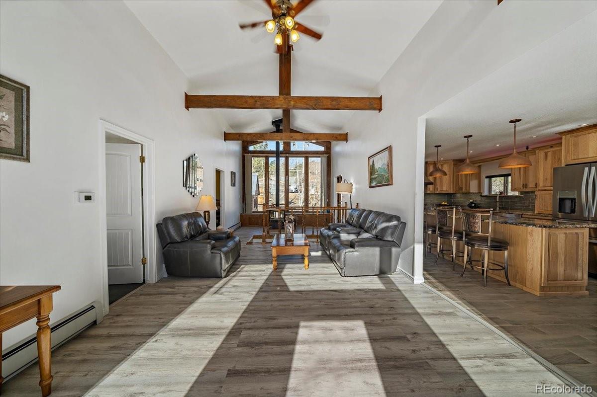 233 Saddlestring Road Bailey, CO 80421 - Photo 7 of 39 a living room with furniture a chandelier and a dining table