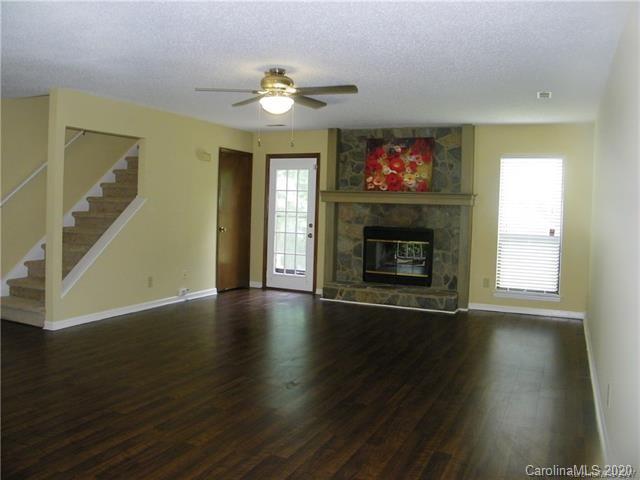 9301 Chislehurst Road Mint Hill, NC 28227 - Photo 5 of 9 a view of an empty room with wooden floor fireplace and a window