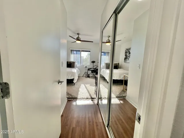 a bedroom with a bed a couch and a flat screen tv