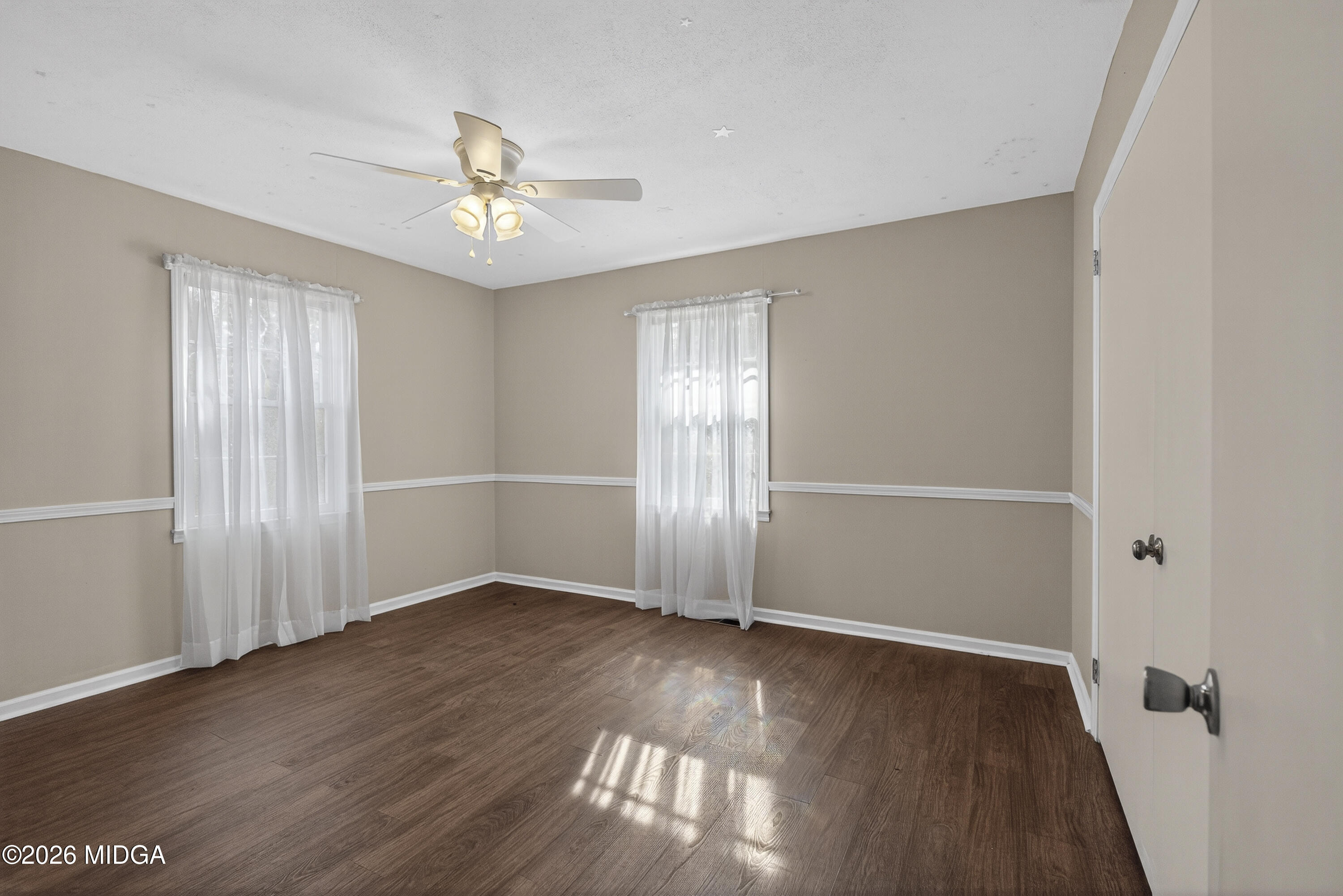337 Highway 18 Gray, GA 31032 - Photo 24 of 50 an empty room with wooden floor chandelier fan and windows