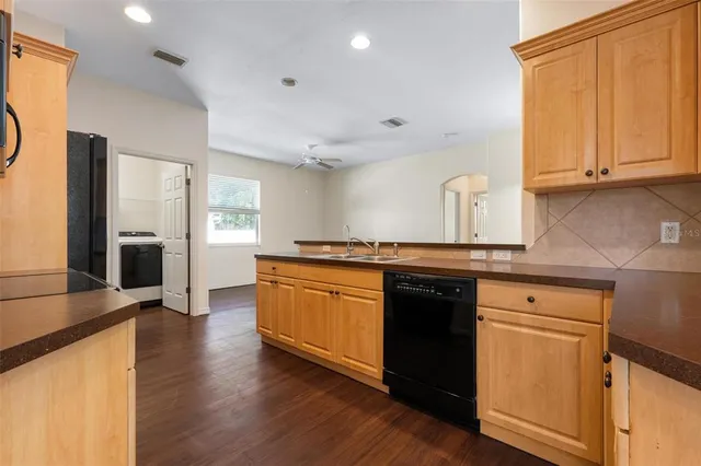 a kitchen with granite countertop a refrigerator and a stove top oven