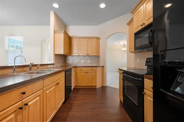 a kitchen with granite countertop a sink stainless steel appliances and cabinets