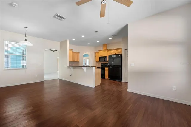 a view of a kitchen with a refrigerator wooden floor and a kitchen view