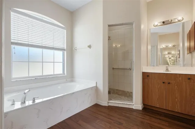 a bathroom with a tub shower and sink