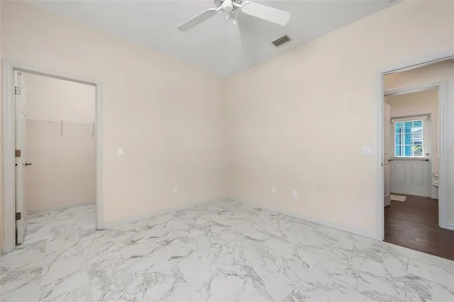 an empty room with a window and a ceiling fan