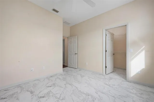 a bathroom with a granite countertop sink a toilet a mirror and a window