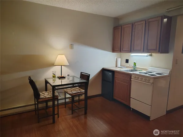 a room with a table chairs and a kitchen view