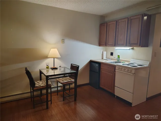 a room with a table chairs and a kitchen view