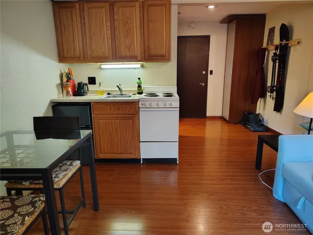 a kitchen with wooden floors and wooden cabinets
