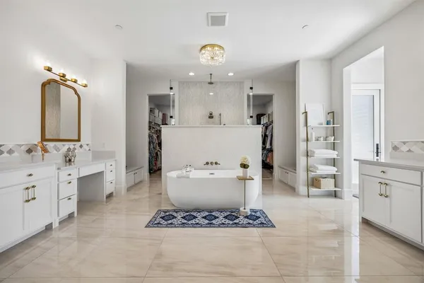 a spacious bathroom with a double vanity sink mirror and bathtub