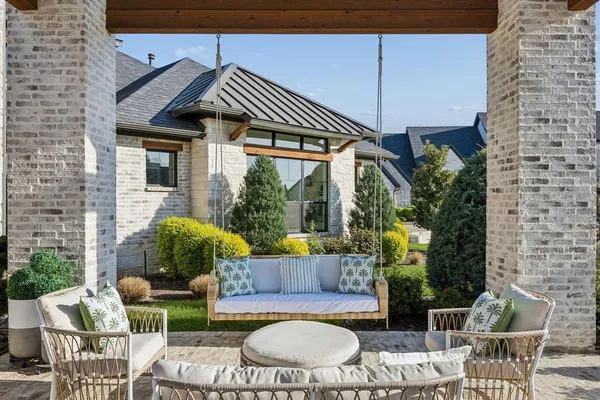 a view of a patio with table and chairs potted plants and floor to ceiling window