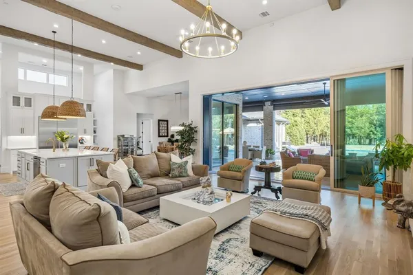 a living room with furniture a chandelier and a dining table