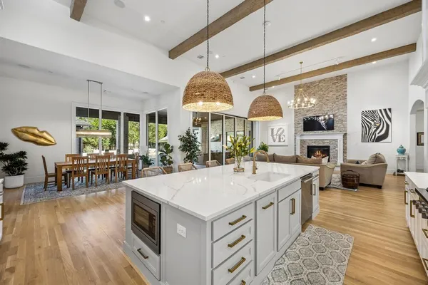 a kitchen with kitchen island a stove a table and chairs in it