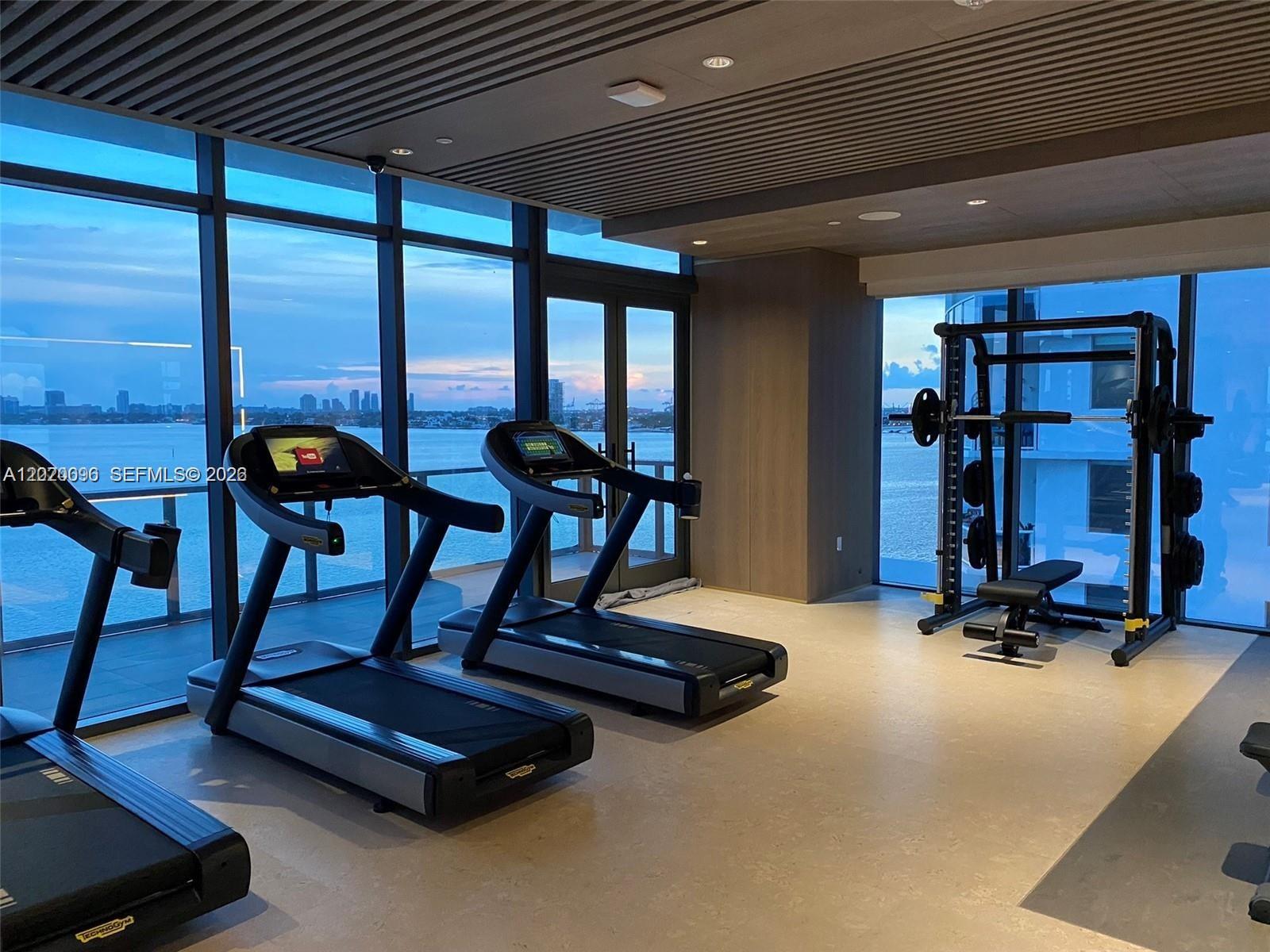 788 Northeast 23rd Street, Unit 1202 Miami, FL 33137 - Photo 53 of 64 a room with gym equipment and large windows