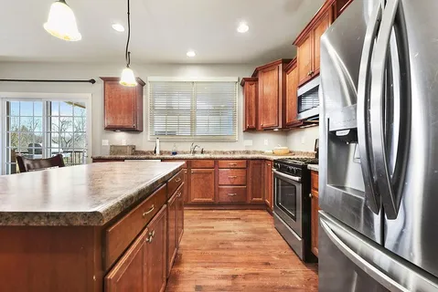 a kitchen with stainless steel appliances granite countertop a stove a sink and a refrigerator