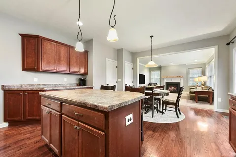 a kitchen with a table chairs and wooden floor