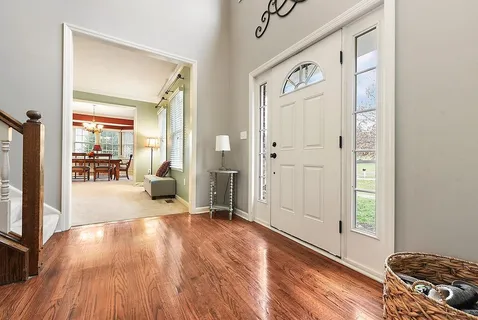 a view of a hallway with wooden floor and furniture