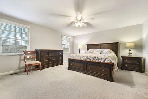 a spacious bedroom with a bed and a chandelier
