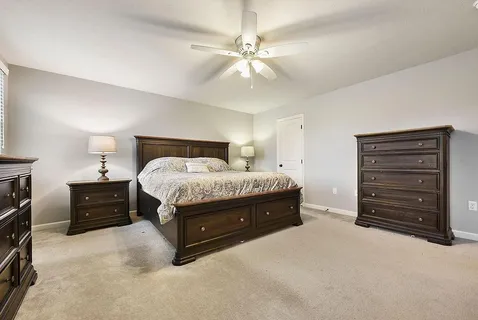 a spacious bedroom with a bed and a ceiling fan