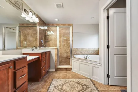 a bathroom with a granite countertop sink toilet and shower