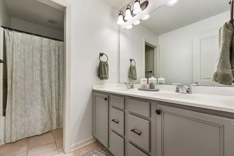 a bathroom with a double vanity sink and a mirror